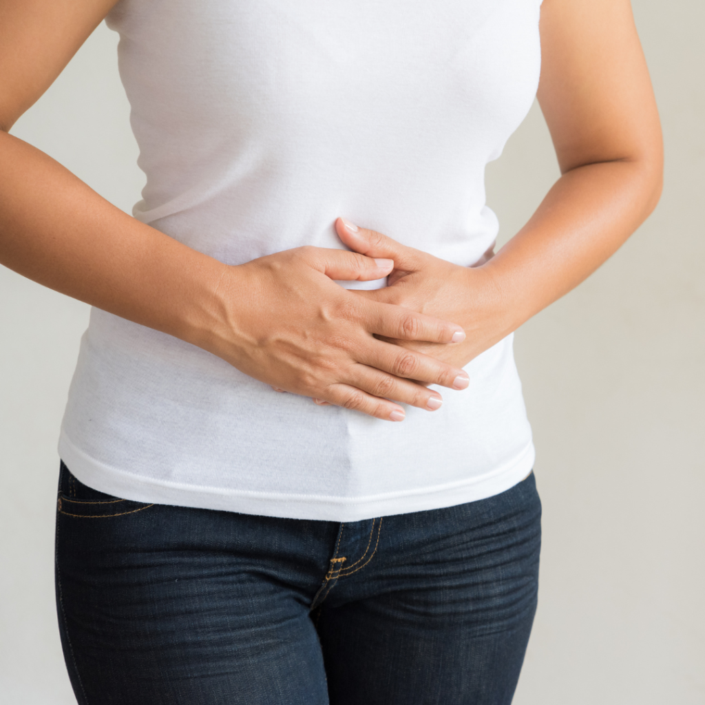 woman holding onto her bloated stomague