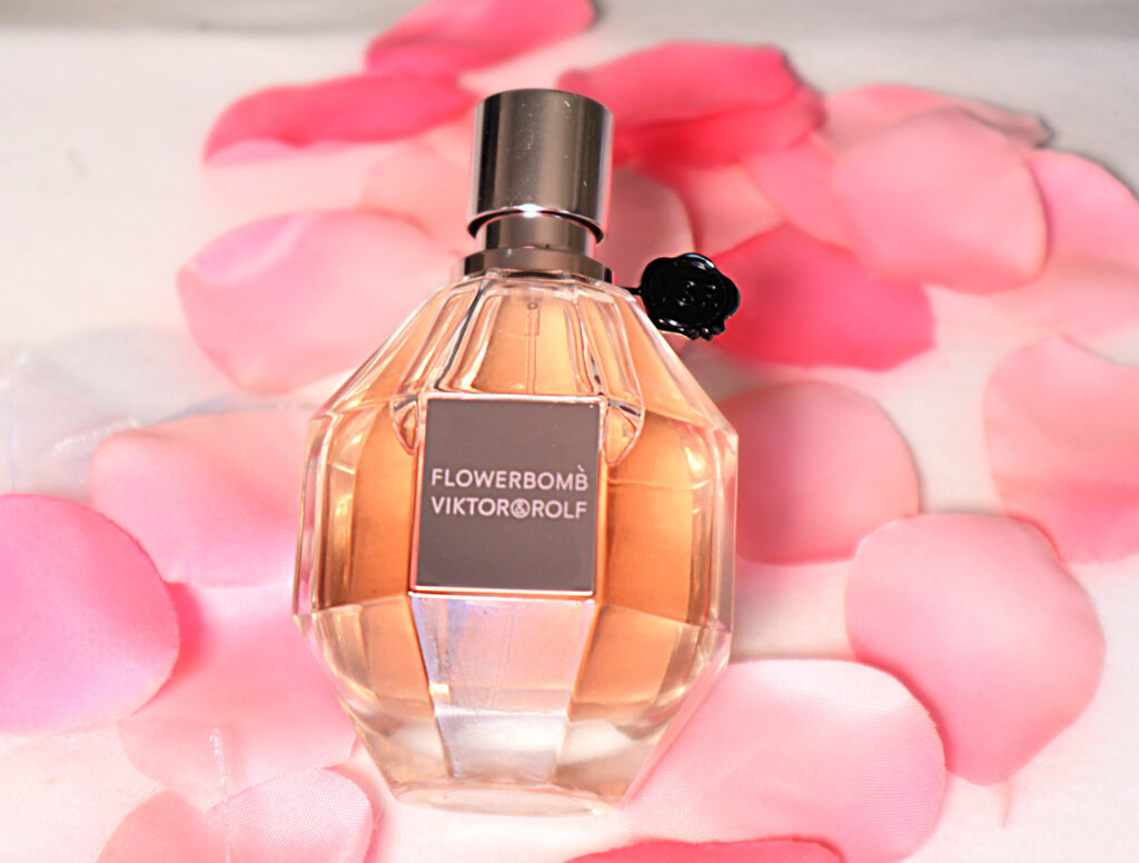 bottle of flowerbomb in between pink rose petals